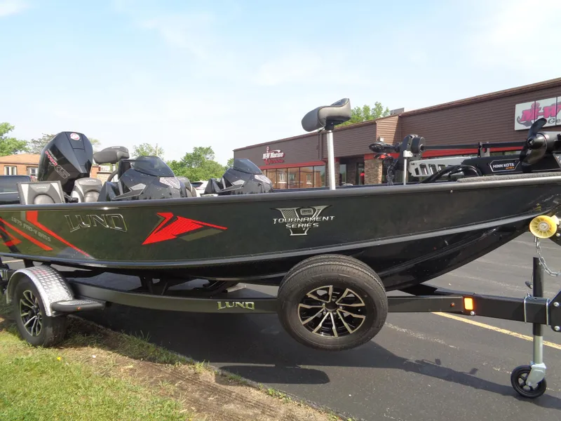Slide: The Image of 2025 Lund 1875 Pro-V Bass XS boat on trailer, parked outdoors. - 7