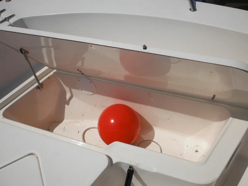 Slide: The Image of Open storage compartment on 2004 Sea Hunt 202 TRITON boat with red buoy inside. - 15