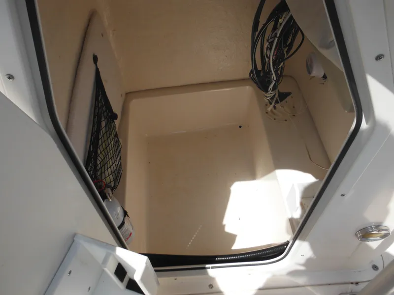 Slide: The Image of Storage compartment of a 2004 Sea Hunt 202 TRITON boat, featuring wiring and a fire extinguisher. - 22