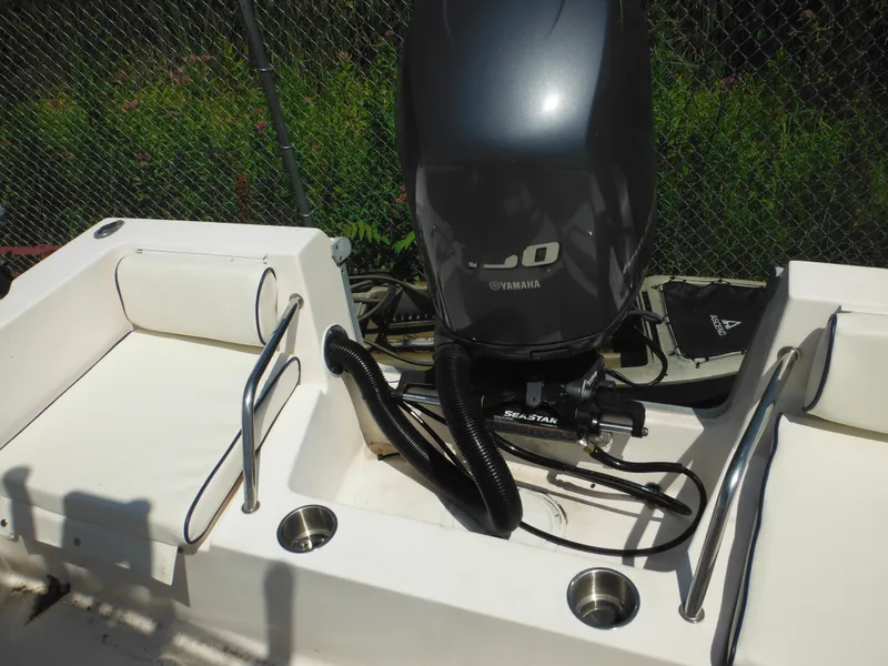 Slide: The Image of 2004 Sea Hunt 202 TRITON boat with Yamaha engine, featuring a clean white deck and seating area. - 28