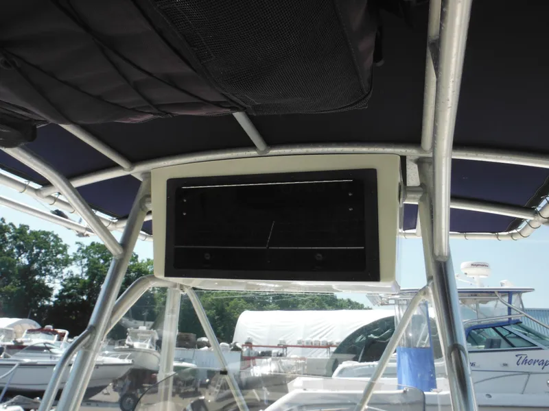 Slide: The Image of T-top console of a 2004 Sea Hunt 202 TRITON boat, docked with other vessels. - 39