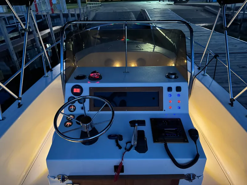 Slide: The Image of Helm of 1987 Custom Biddison 2200 boat at dock, illuminated controls and steering wheel. - 10