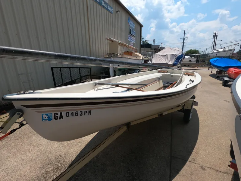 Slide: The Image of 1980 Spindrift Rascal 14 sailboat on trailer, parked outdoors under a partly cloudy sky. - 2