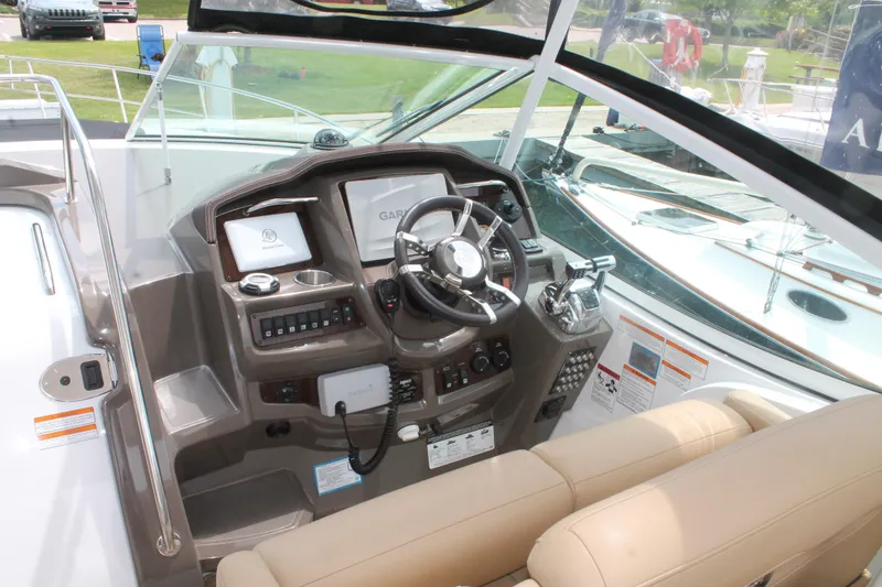 Slide: The Image of Helm of 2014 Cruisers Yachts 350 Express with modern controls and beige seating. - 10