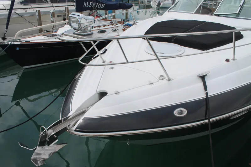Slide: The Image of 2014 Cruisers Yachts 350 Express docked, showcasing sleek design and anchor detail. - 2