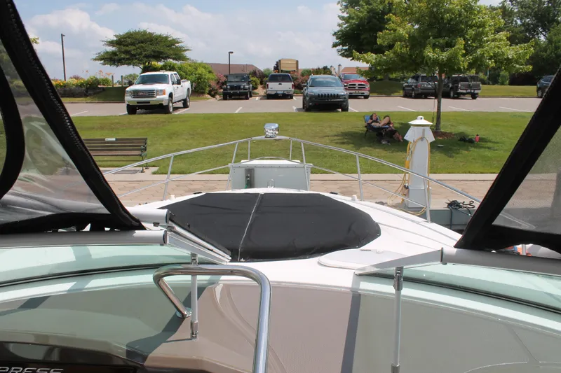 Slide: The Image of 2014 Cruisers Yachts 350 Express docked, view from bow with parked cars in background. - 22