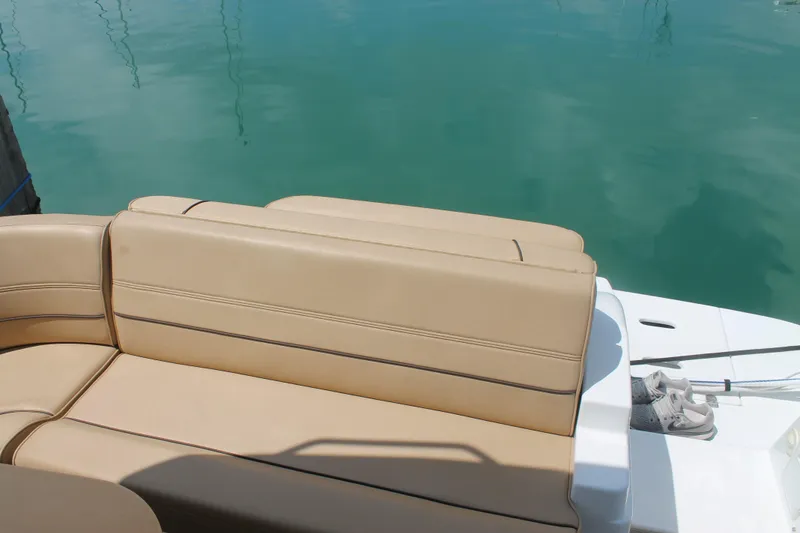 Slide: The Image of 2014 Cruisers Yachts 350 Express beige seating by turquoise water. - 33