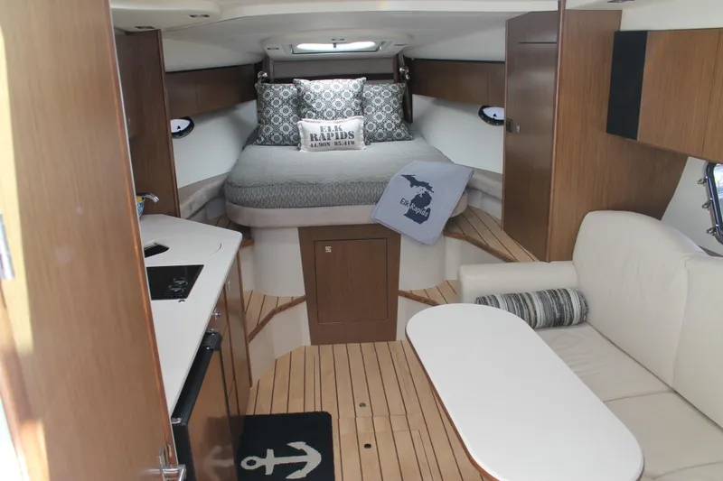 Slide: The Image of 2014 Cruisers Yachts 350 Express interior with bed, seating, and kitchenette. - 34