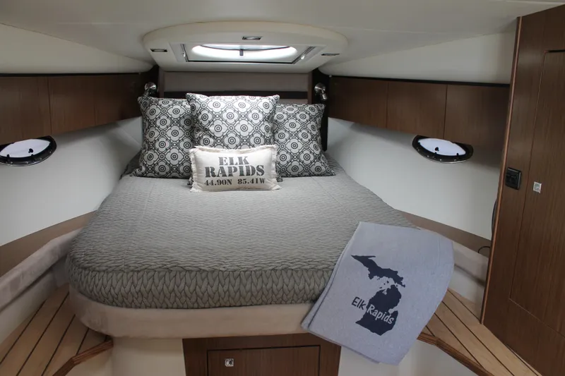 Slide: The Image of 2014 Cruisers Yachts 350 Express cabin with cozy bed, decorative pillows, and Elk Rapids blanket. - 35