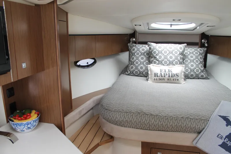 Slide: The Image of 2014 Cruisers Yachts 350 Express cabin with cozy bed, wooden accents, and decorative pillows. - 36