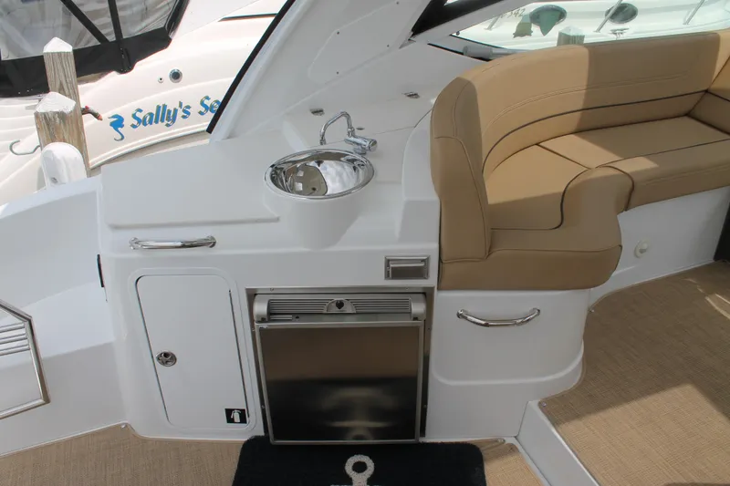 Slide: The Image of 2014 Cruisers Yachts 350 Express interior with sink, seating, and mini fridge. - 7