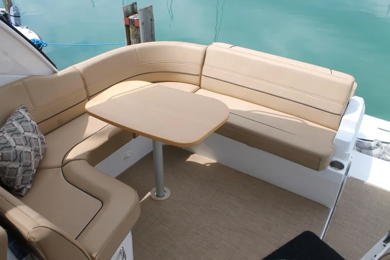 Slide: The Image of 2014 Cruisers Yachts 350 Express interior with beige seating and table. - 8