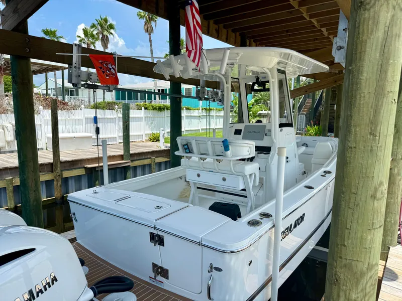 Slide: The Image of 2023 Regulator 23 boat docked under wooden shelter with Yamaha engine. - 11