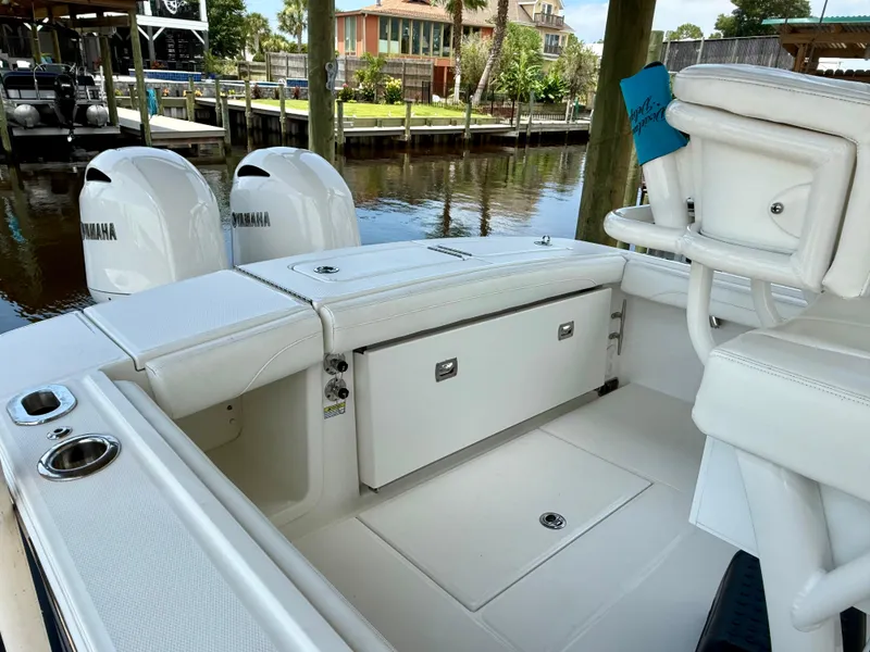 Slide: The Image of 2023 Regulator 23 boat interior with Yamaha engines, docked by waterfront homes. - 16
