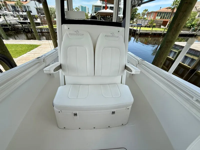 Slide: The Image of 2023 Regulator 23 boat interior with white seating, dockside view. - 20