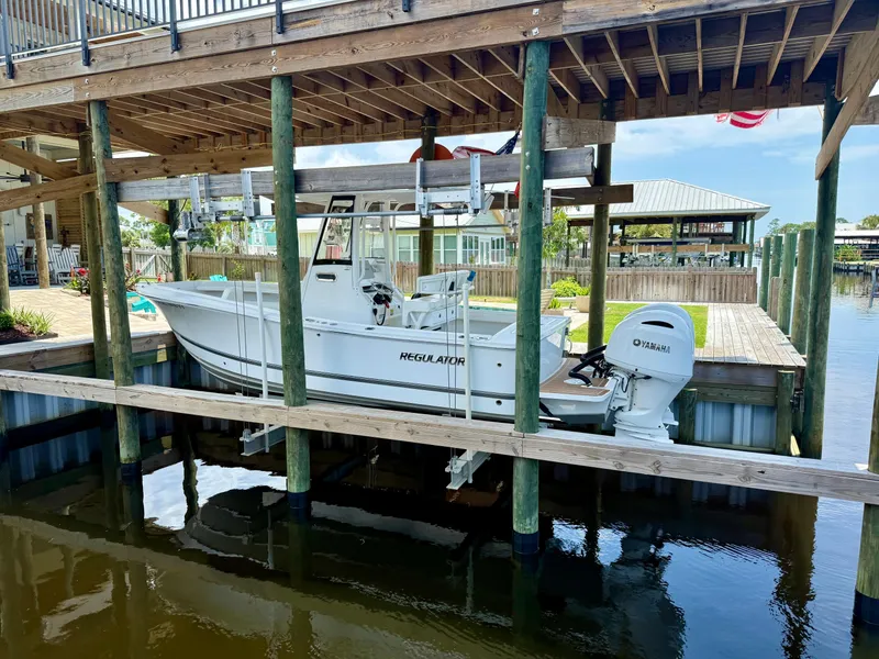 Slide: The Image of 2023 Regulator 23 boat docked under wooden shelter with Yamaha outboard motor. - 5