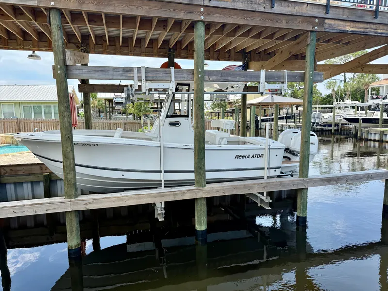 Slide: The Image of 2023 Regulator 23 boat docked in a marina, elevated on a lift. - 6