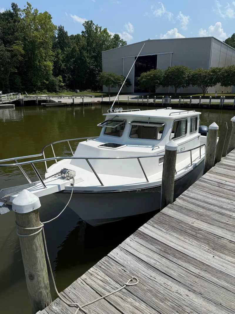 Slide: The Image of 2020 Parker 2530 Extended Sport Cabin boat docked by a wooden pier. - 3