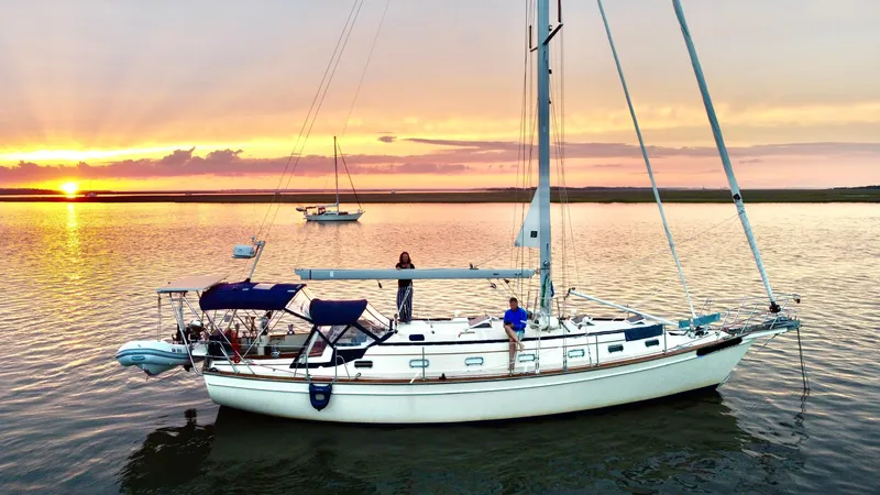 Slide: The Image of Sailboat Island Packet 45, 1999 model, anchored at sunset on calm waters. - 1