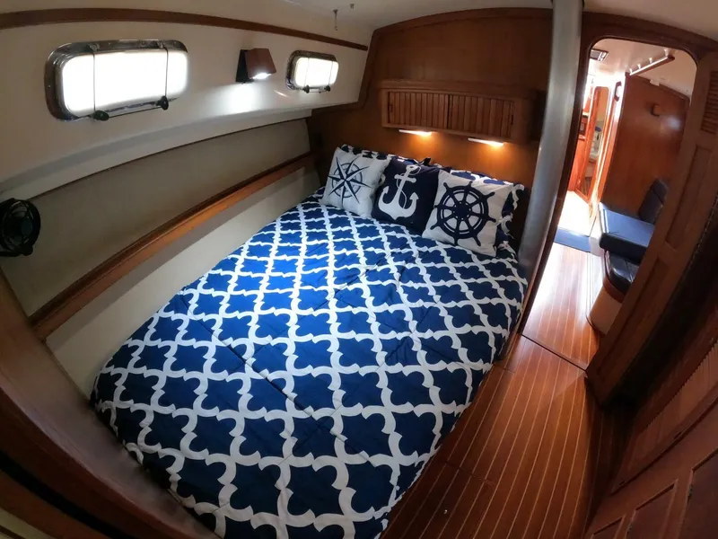 Slide: The Image of Cozy cabin interior of 1999 Island Packet 45 sailboat with nautical-themed bedding. - 19