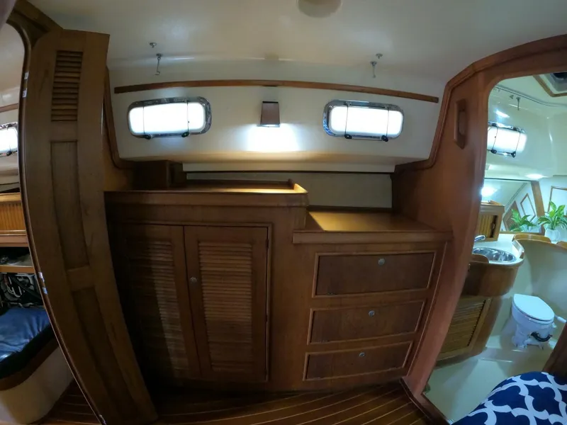 Slide: The Image of Interior of 1999 Island Packet 45 sailboat with wooden cabinetry and bathroom view. - 21