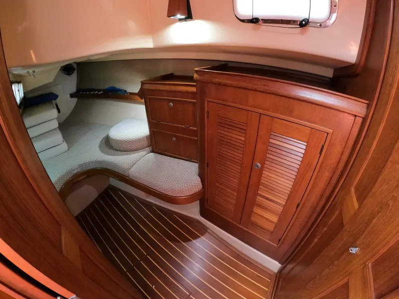 Slide: The Image of Interior of 1999 Island Packet 45 sailboat with wooden cabinetry and cozy seating area. - 26