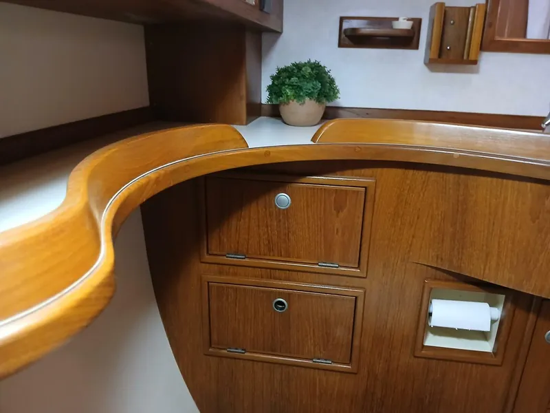 Slide: The Image of Interior of 1999 Island Packet 45 sailboat with wooden cabinetry and potted plant. - 31