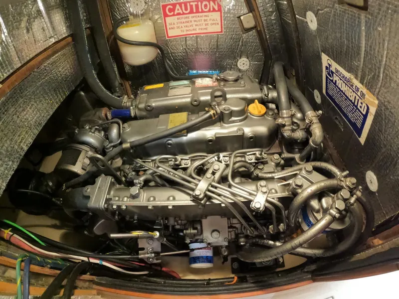 Slide: The Image of Engine compartment of a 1999 Island Packet 45 sailboat, showcasing detailed mechanical components. - 38