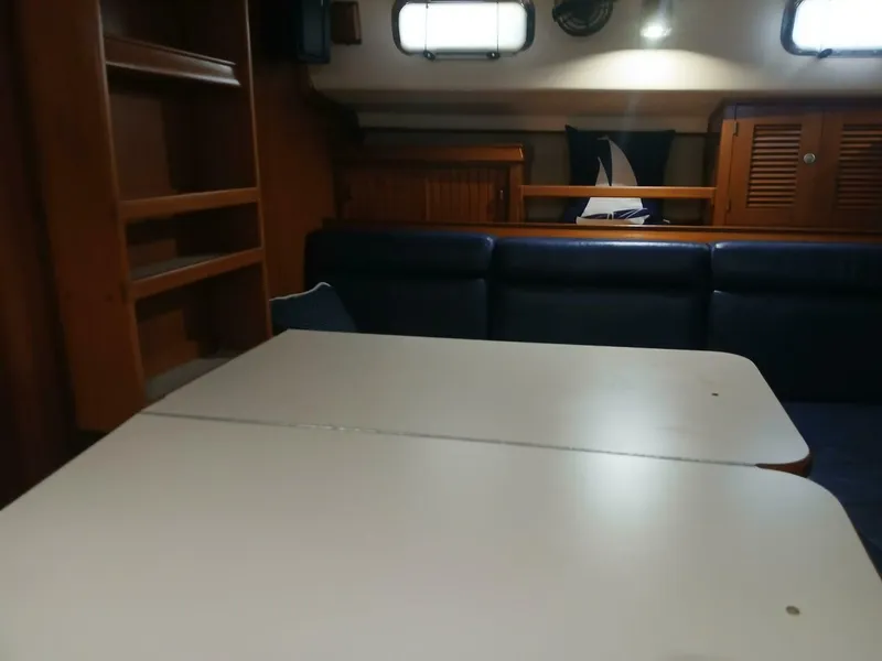Slide: The Image of Interior of 1999 Island Packet 45 sailboat with table, seating, and wooden cabinetry. - 6