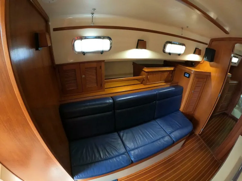 Slide: The Image of Interior of 1999 Island Packet 45 yacht with blue leather seating and wooden cabinetry. - 9
