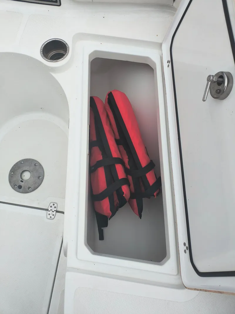 Slide: The Image of Storage compartment on 2020 Wellcraft 222 Fisherman boat with red life jackets. - 19