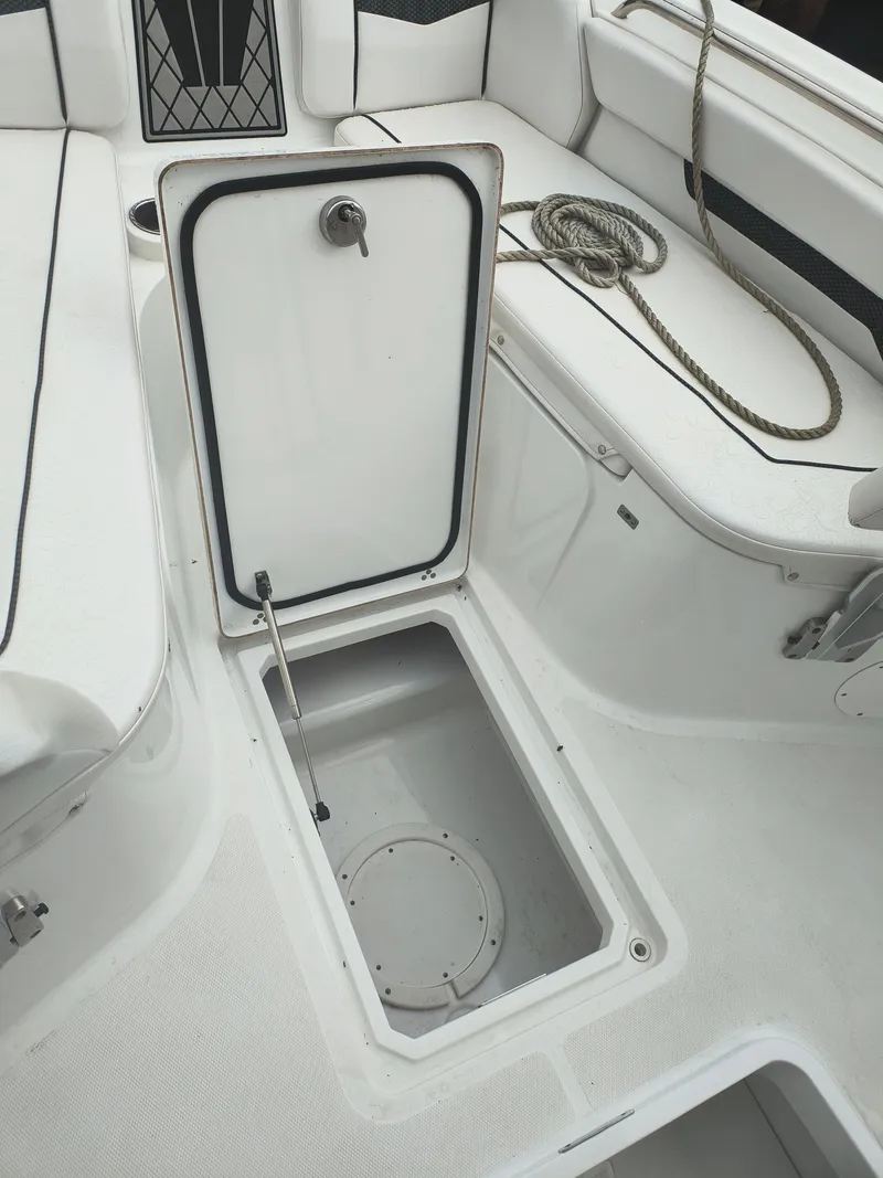 Slide: The Image of Open storage compartment on 2020 Wellcraft 222 Fisherman boat deck, with coiled rope nearby. - 23