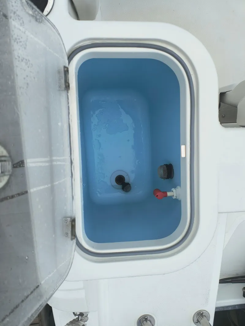 Slide: The Image of Livewell on 2020 Wellcraft 222 Fisherman boat, open lid, blue interior. - 24