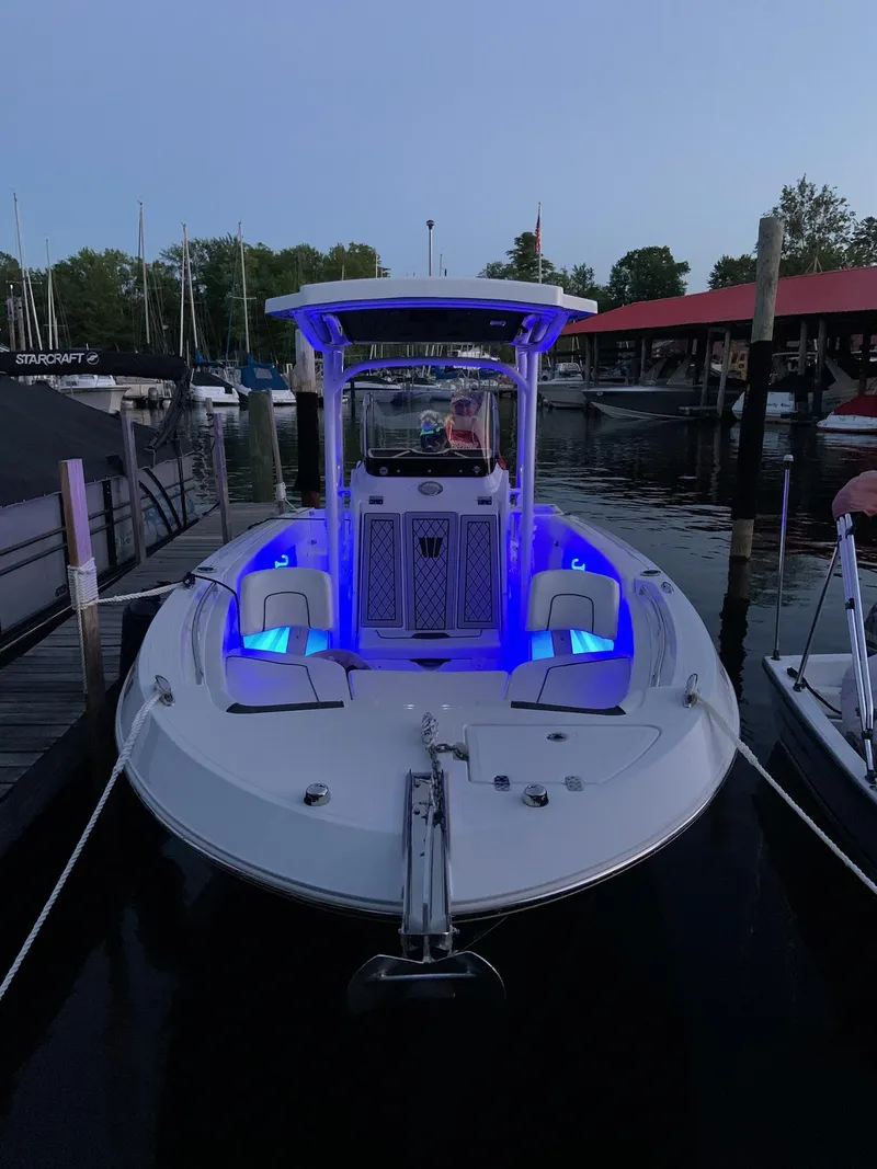 Slide: The Image of 2020 Wellcraft 222 Fisherman boat docked with blue interior lights at dusk. - 3