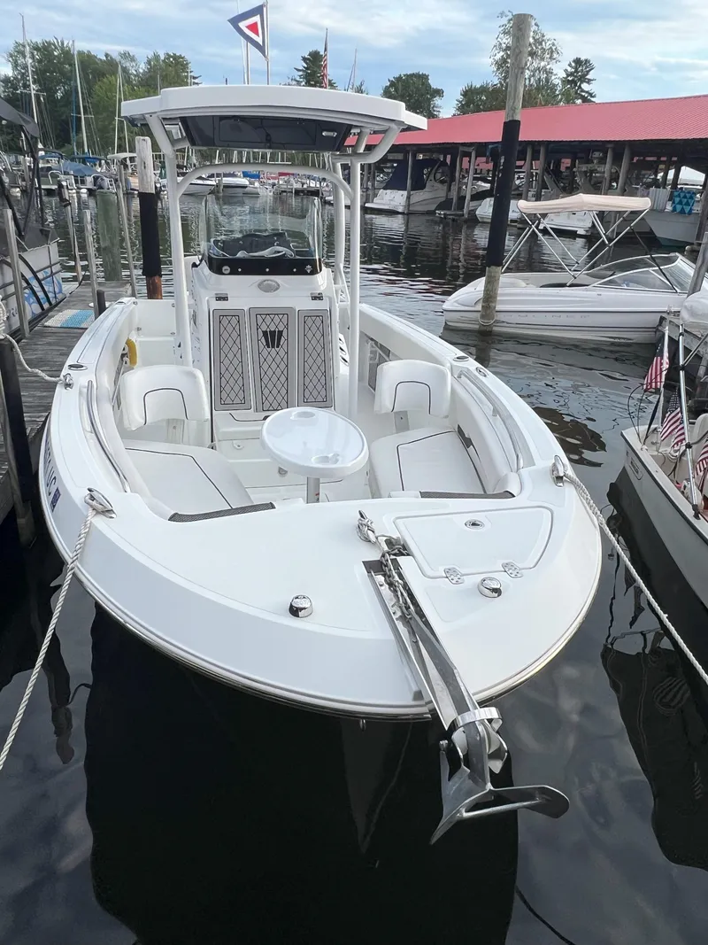 Slide: The Image of 2020 Wellcraft 222 Fisherman boat docked at a marina, featuring a sleek white design. - 8