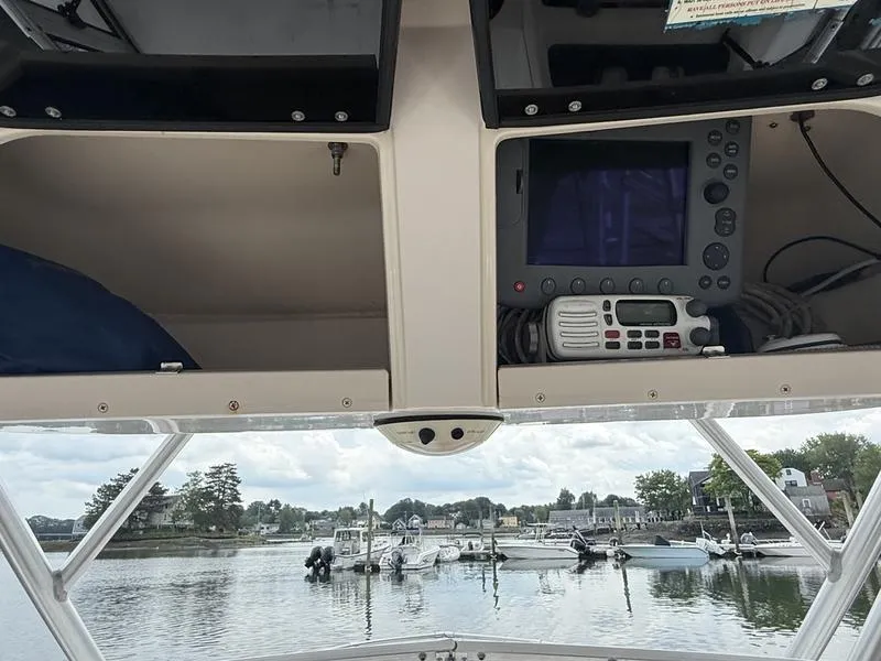Slide: The Image of 2003 Grady-White 226 Sea Farer boat dashboard with navigation equipment, docked at a marina. - 8