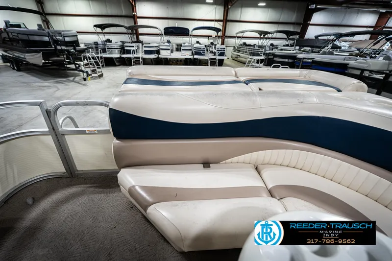 Slide: The Image of 2007 Bennington 2050 GL pontoon boat interior in showroom with multiple boats. - 18