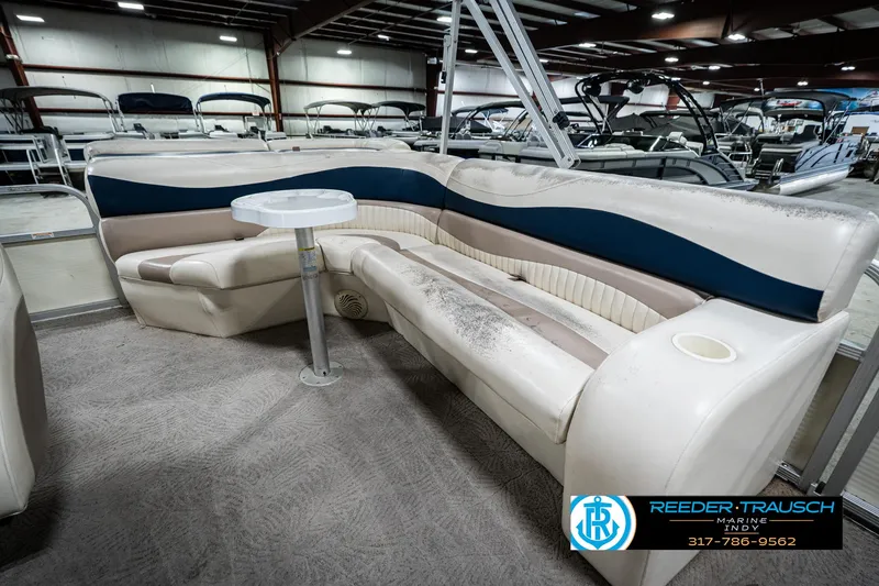 Slide: The Image of 2007 Bennington 2050 GL pontoon boat interior with seating and table in showroom. - 26