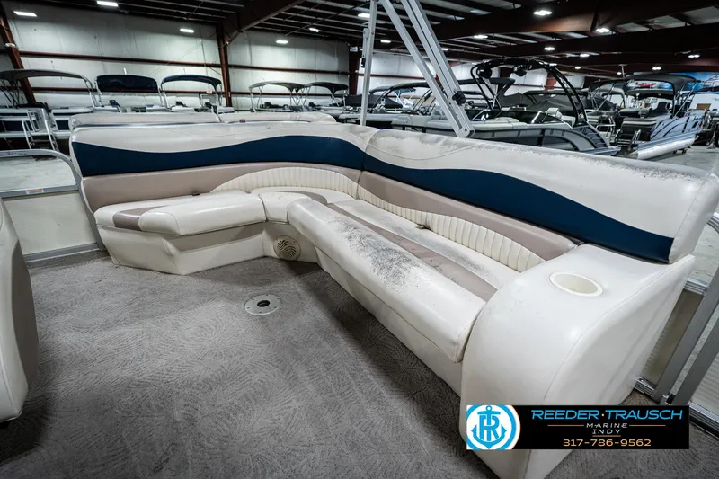 Slide: The Image of 2007 Bennington 2050 GL boat interior with white and blue seating in a showroom. - 27