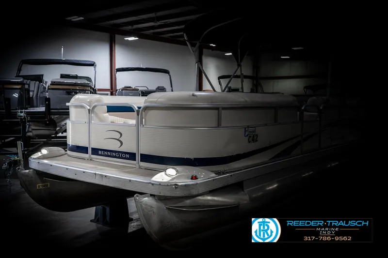 Slide: The Image of 2007 Bennington 2050 GL pontoon boat in a dimly lit showroom. - 4