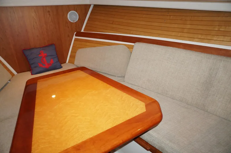 Slide: The Image of Cozy interior of 2006 Back Cove 29 boat with wooden table and cushioned seating. - 14