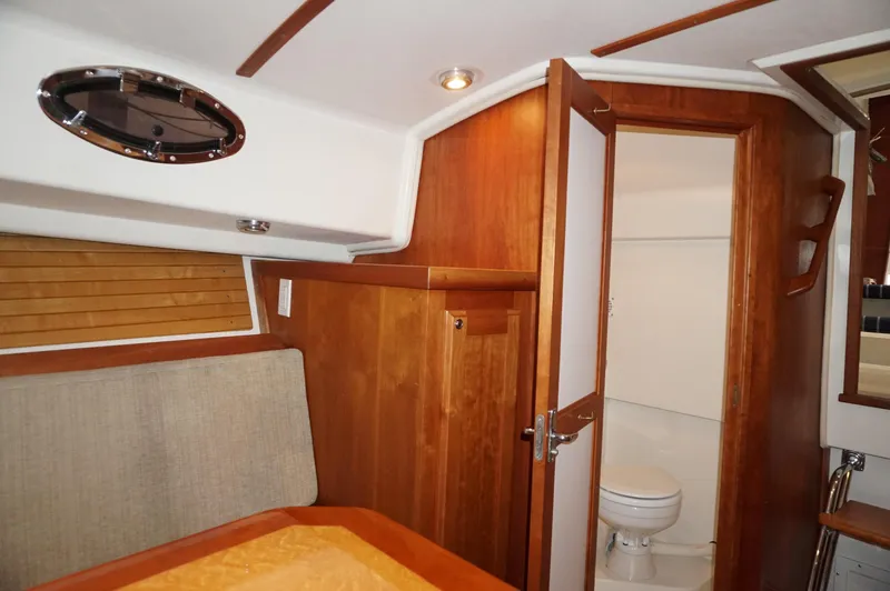 Slide: The Image of Interior of 2006 Back Cove 29 boat, featuring wooden cabinetry and a compact bathroom. - 15