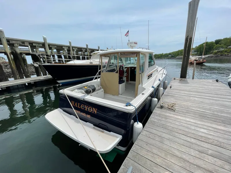 Slide: The Image of 2006 Back Cove 29 boat docked at a marina, named "Halcyon," Portland, ME. - 2