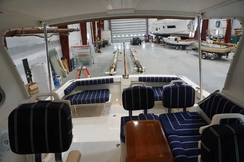Slide: The Image of Interior view of 2006 Back Cove 29 boat with striped seating in a spacious garage. - 25
