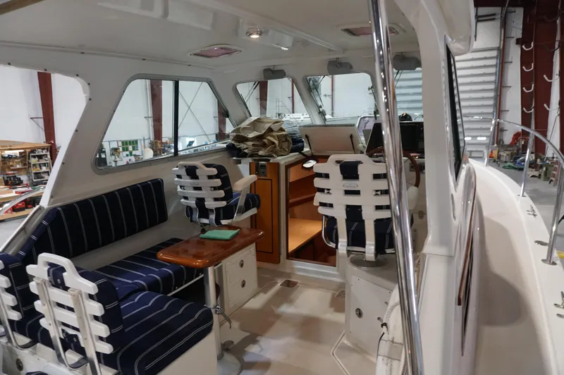 Slide: The Image of Interior of 2006 Back Cove 29 boat with striped seating and wooden table. - 28