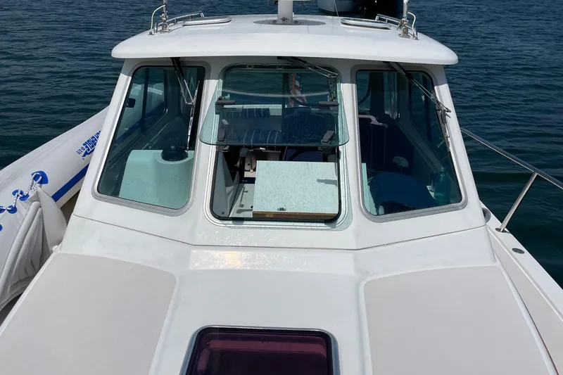 Slide: The Image of 2006 Back Cove 29 boat with cabin windows, docked on calm water. - 3