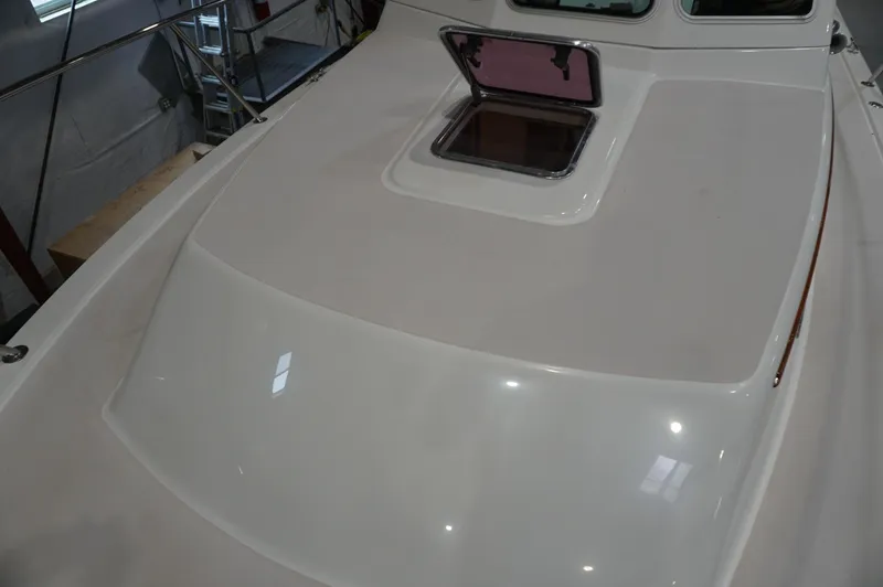 Slide: The Image of 2006 Back Cove 29 boat deck with open hatch in indoor setting. - 34