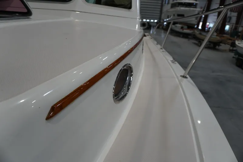 Slide: The Image of 2006 Back Cove 29 boat deck with wood trim and porthole in a marina. - 35