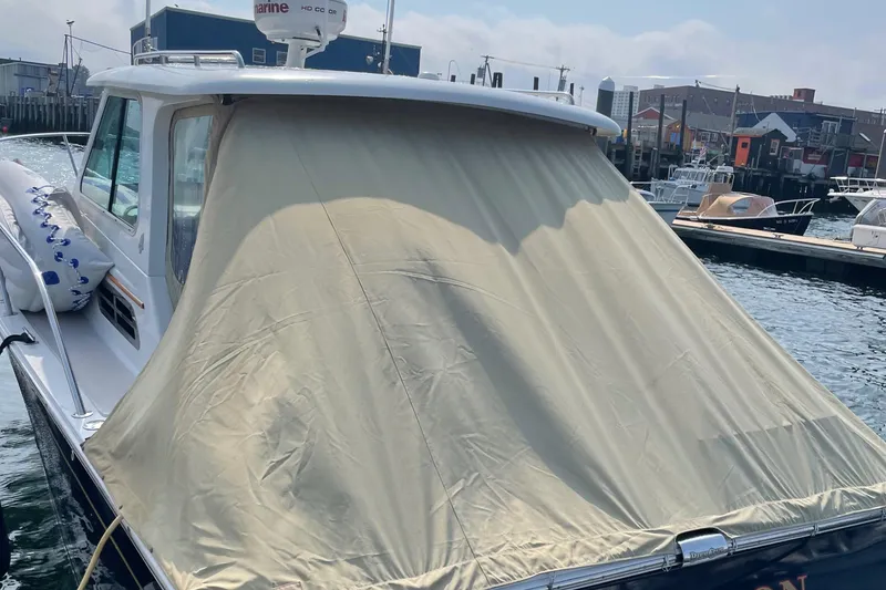 Slide: The Image of 2006 Back Cove 29 boat with beige cover docked at marina. - 4