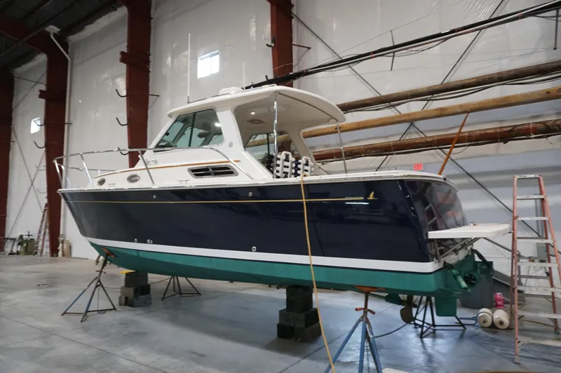 Slide: The Image of 2006 Back Cove 29 boat in a warehouse, elevated on stands for maintenance. - 7